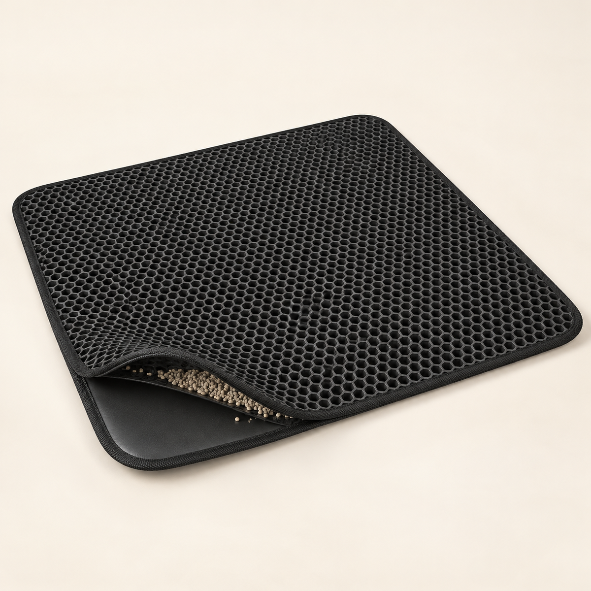 Black PawProof double-layer litter mat with trapped litter visible between the layers